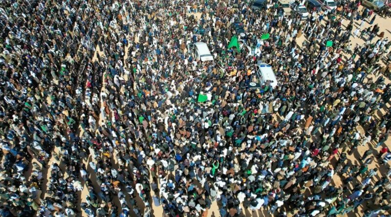 Thousands of Libyans surround an ambulance carrying the coffin of Seif al-Islam