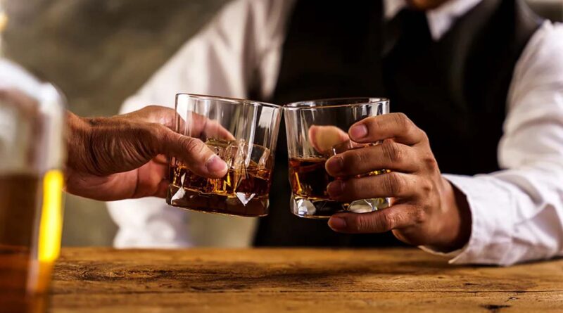 two men holding two glasses of liquer