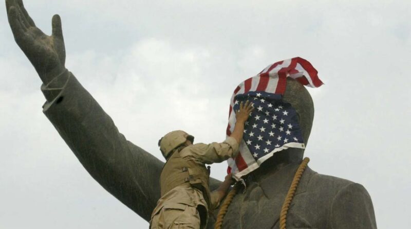 us soilder puting flag of saddam hussains mural
