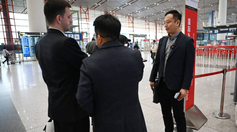 A traveler speaks to the media after checking in for a flight to Pyongyang, North Korea, at Beijing airport
