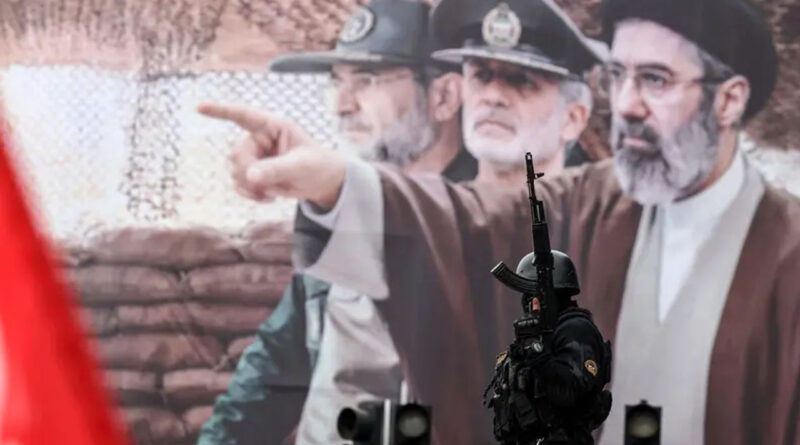 An Iranian security force officer stands guard next to a huge billboard of Iran’s new Supreme Leader Mojtaba Khamenei in Tehran