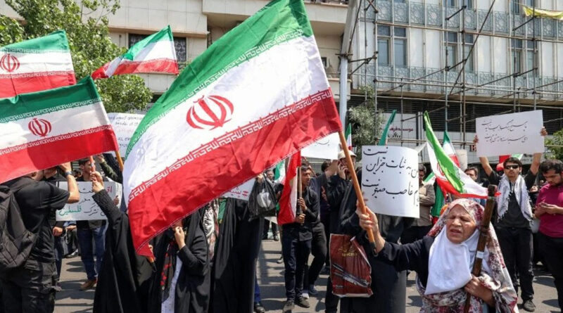crowd waving iranian flag at street