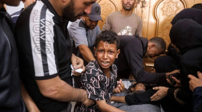 A Palestinian child weeps next to the body of his brother, killed in an Israeli strike in Khan Younis, southern Gaza, on Wednesday