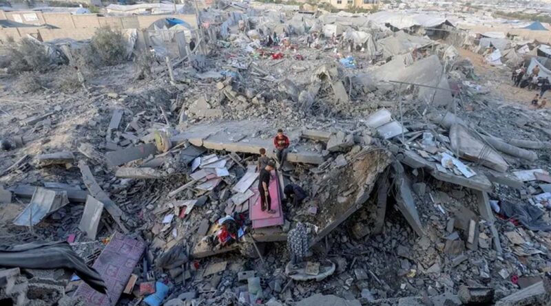 Palestinians inspect the site of an Israeli strike on a house whose residents were warned to evacuate before the attack