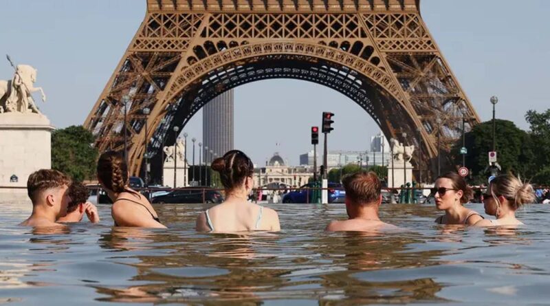 People cool off in the Trocadero Fountain next to the Eiffel Tower as temperatures rise during a heatwave affecting a large part of the country, in Paris, France, June 22, 2026
